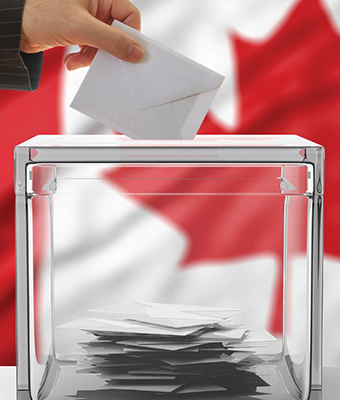 Hand depositing an envelope into a glass box with Canadian flag in the background