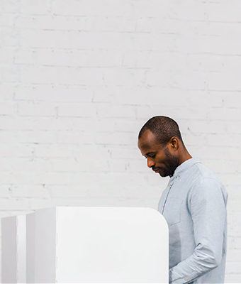 Un homme qui vote à un bureau de scrutin